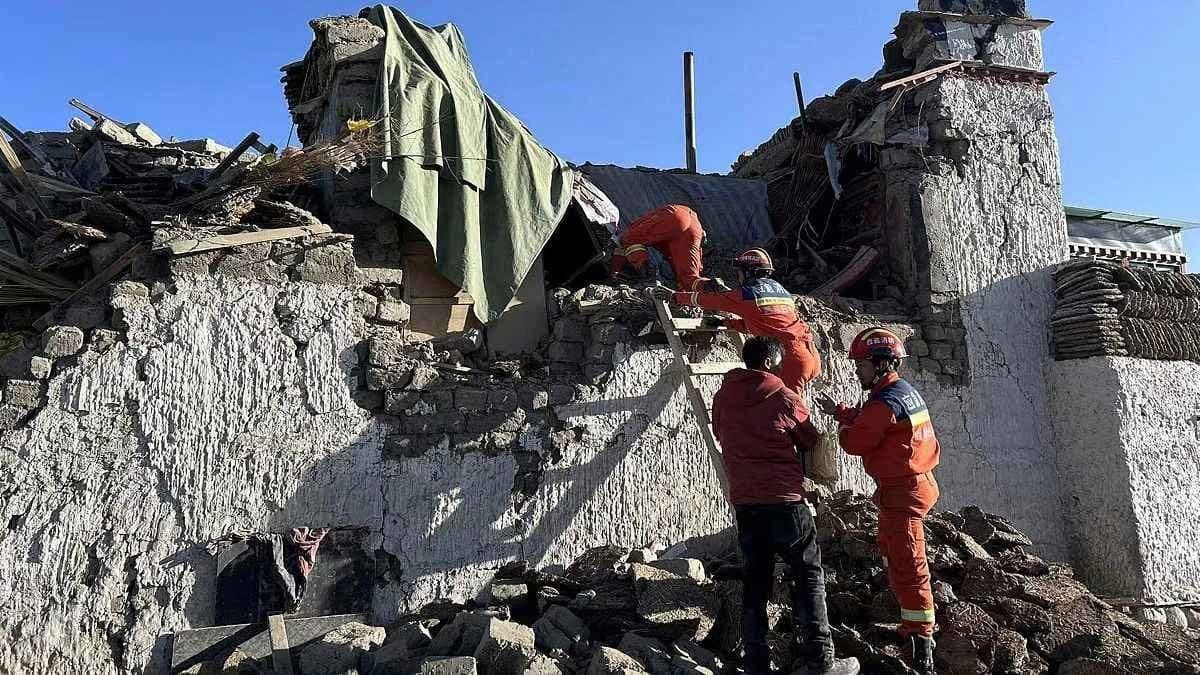 Rescue workers search through the rubble of collapsed buildings following a devastating earthquake in Tibet, with extensive structural damage visible across the area.