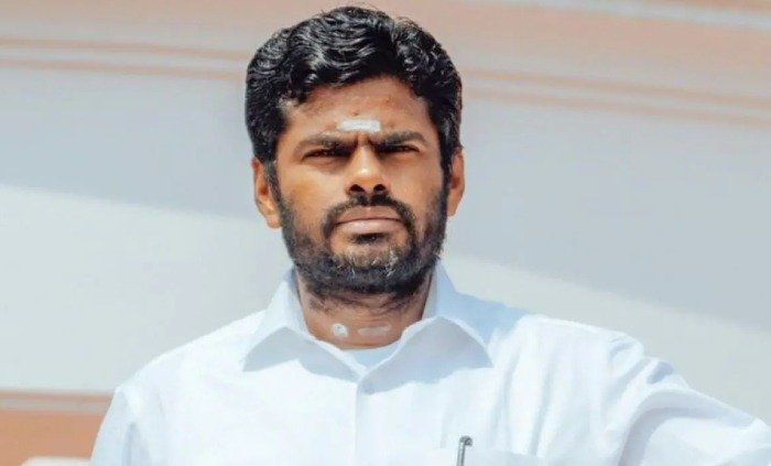 Portrait of BJP leader K. Annamalai in white shirt with vibhuti on forehead.