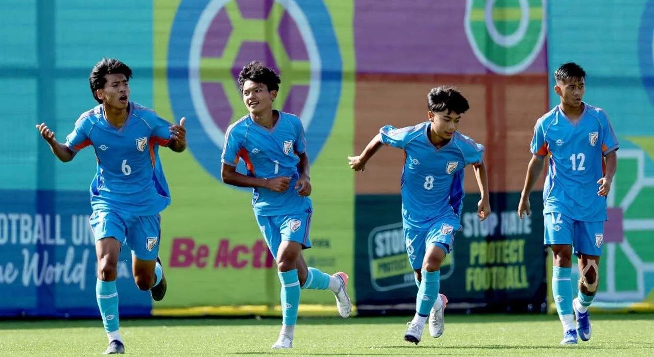 Indian U-15 football players in blue jerseys celebrating during a match at the FIFA U-17 World Cup.