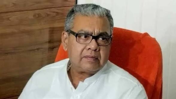 Senior political leader in white kurta sitting on chair during press meeting